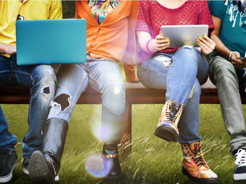 Grupa mladih sjedi i koristi laptope